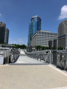 Blick von der Uferpromenade in Jersey City auf die grün-bläulich schimmernden Hochhäuser der 70 Greene Street